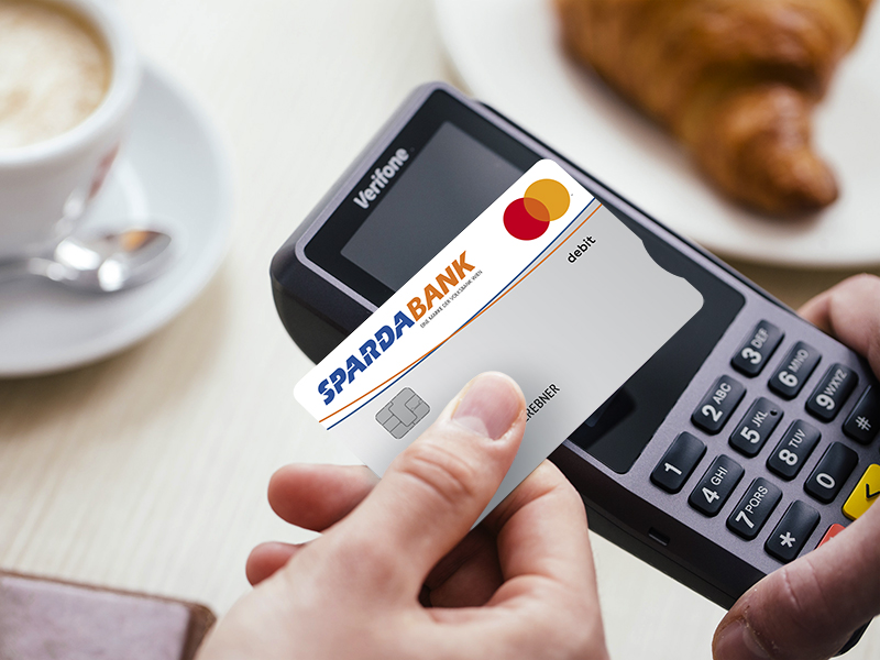 Bild zeigt eine SPARDA-BANK Debit Mastercard beim Bezahlen mit NFC an einer Bankomatkasse.